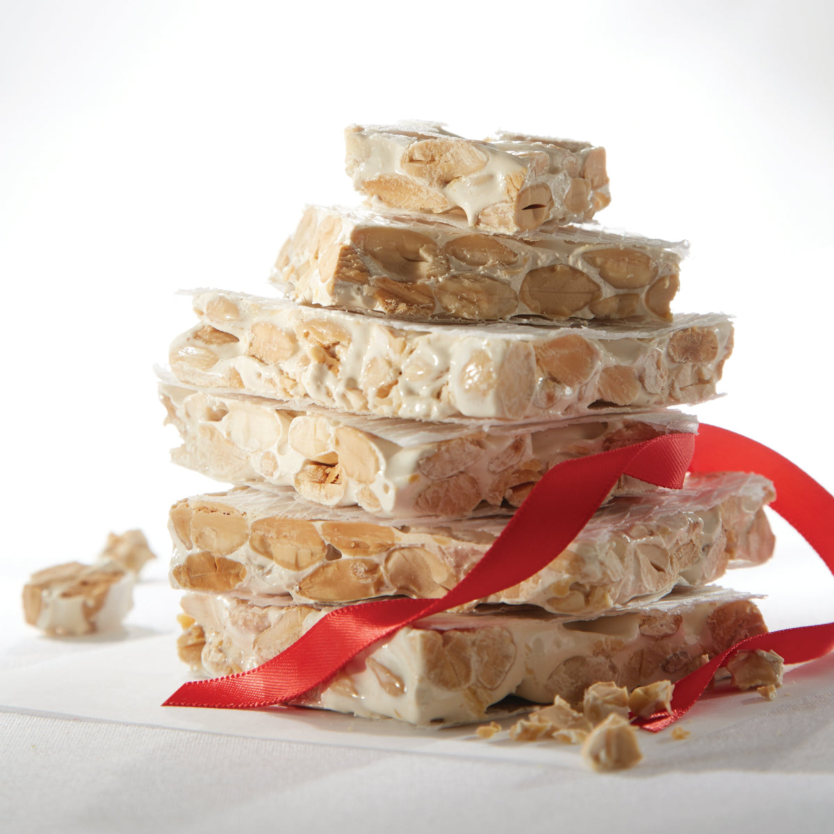 Photo of a stack of almond turron with a red Christmas ribbon