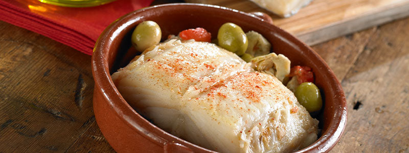 Photo of Bacalao Extra Thick Cod Loin in a terra cotta cazuela with olives