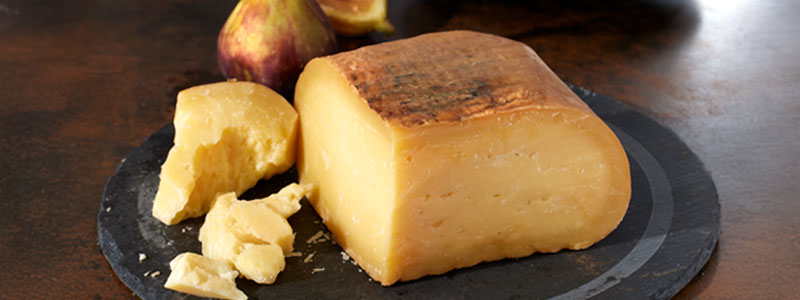 Photo of two tetilla cheeses with one wedge cut out