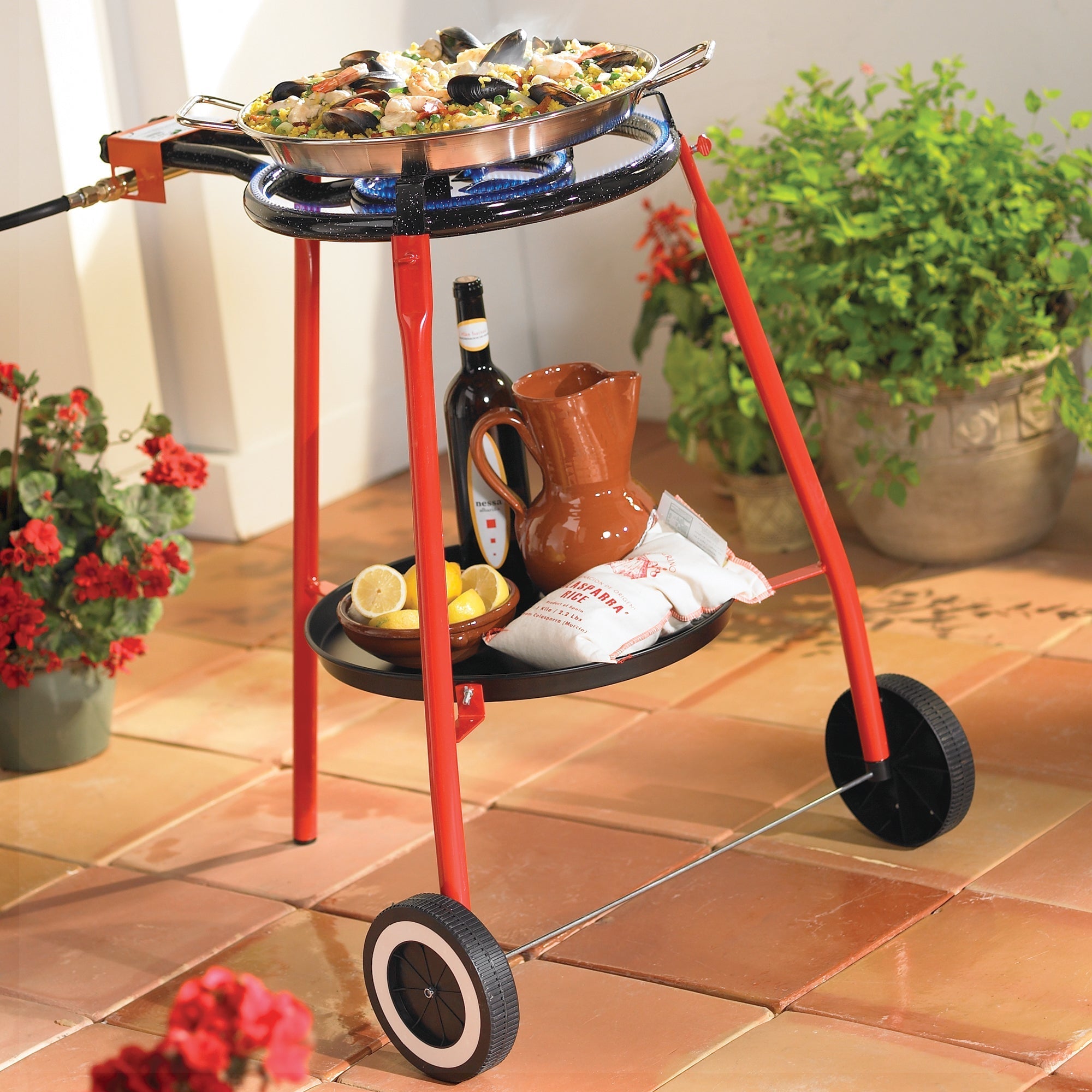 Photo of a Paella Burner with Rolling Stand on a tile patio with a seafood paella on top