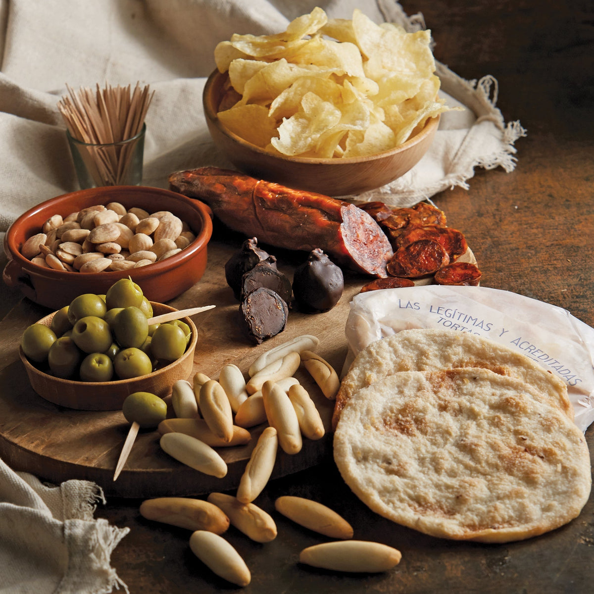 Photo of a tapas spread including olives, rabitos bonbons, almonds and tortas de aceite