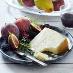 Photo of a wedge of Iberico Cheese on a plate with fruit