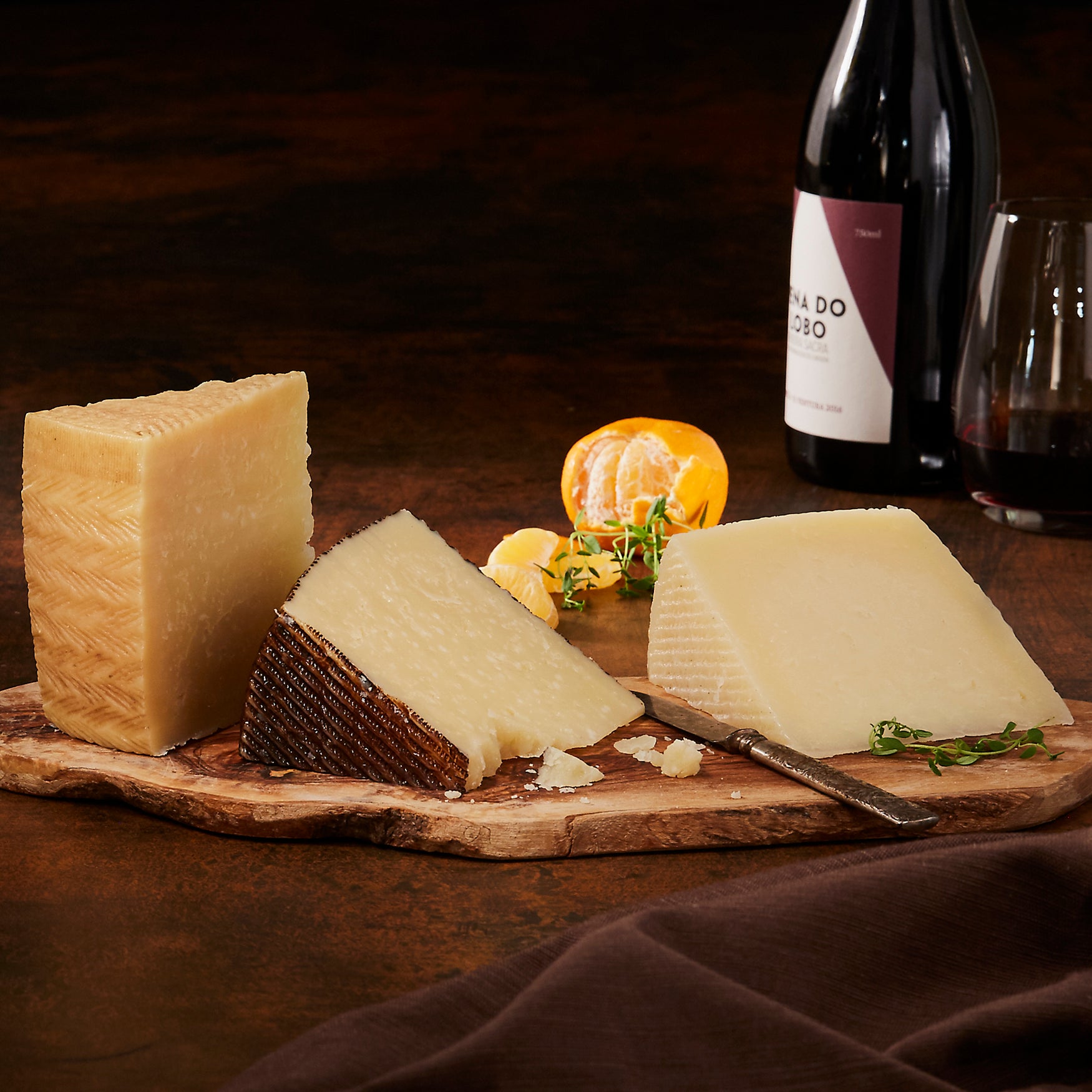 Photo of a cheese board with fruit, olives and Artisan manchego Trio