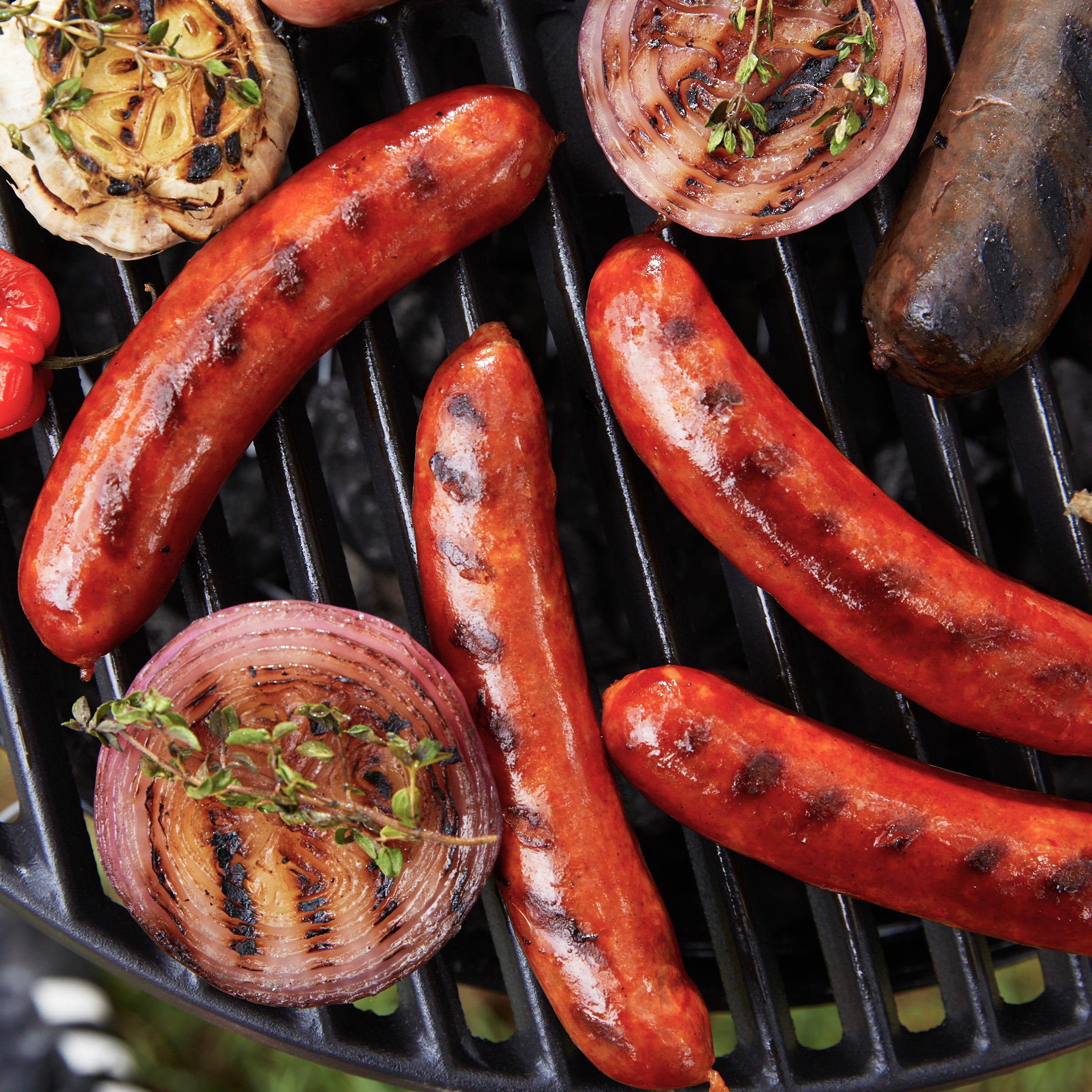 Photo of Iberico Pork Cooking Chorizo on the grill with vegetables and other sausages